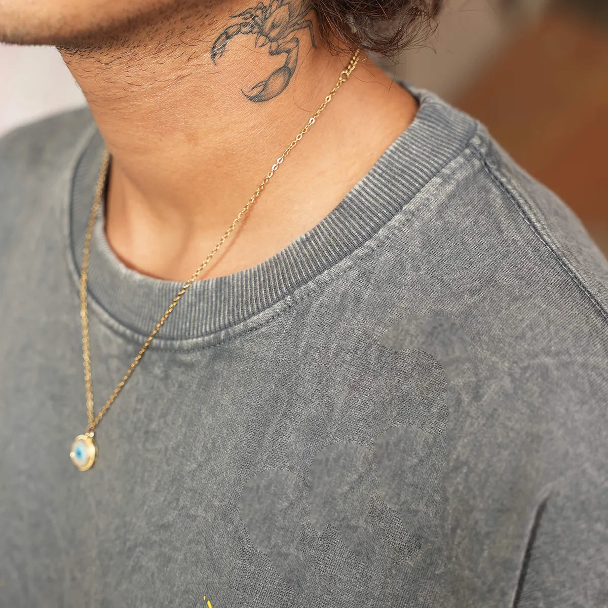 Close-up of golden root design screen print on acid wash black cotton tee