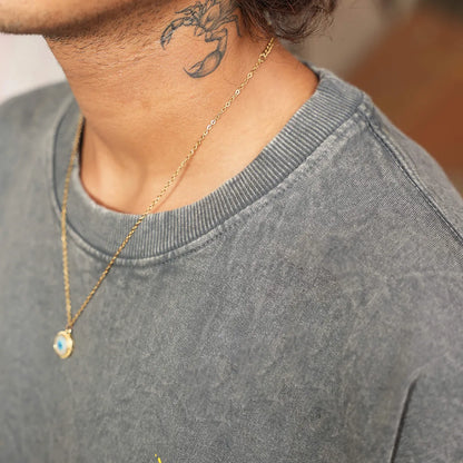 Close-up of golden root design screen print on acid wash black cotton tee